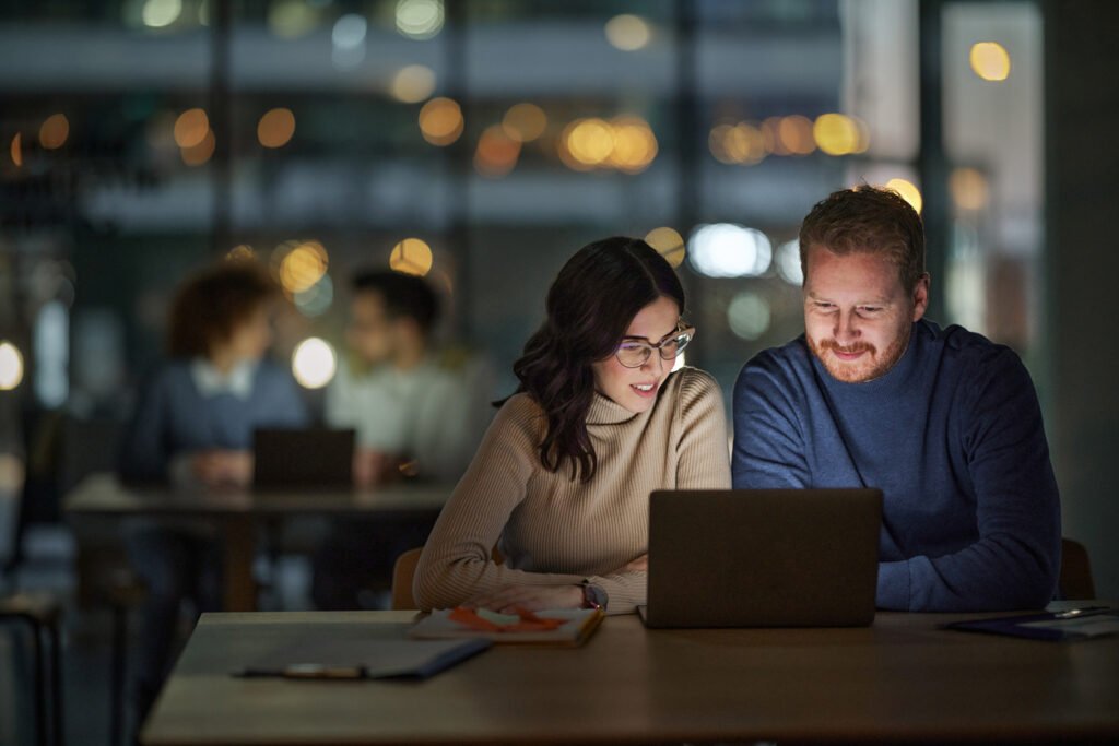 A couple smiling as they make their insurance payment easily and instantly with Valet Finance on their laptop.